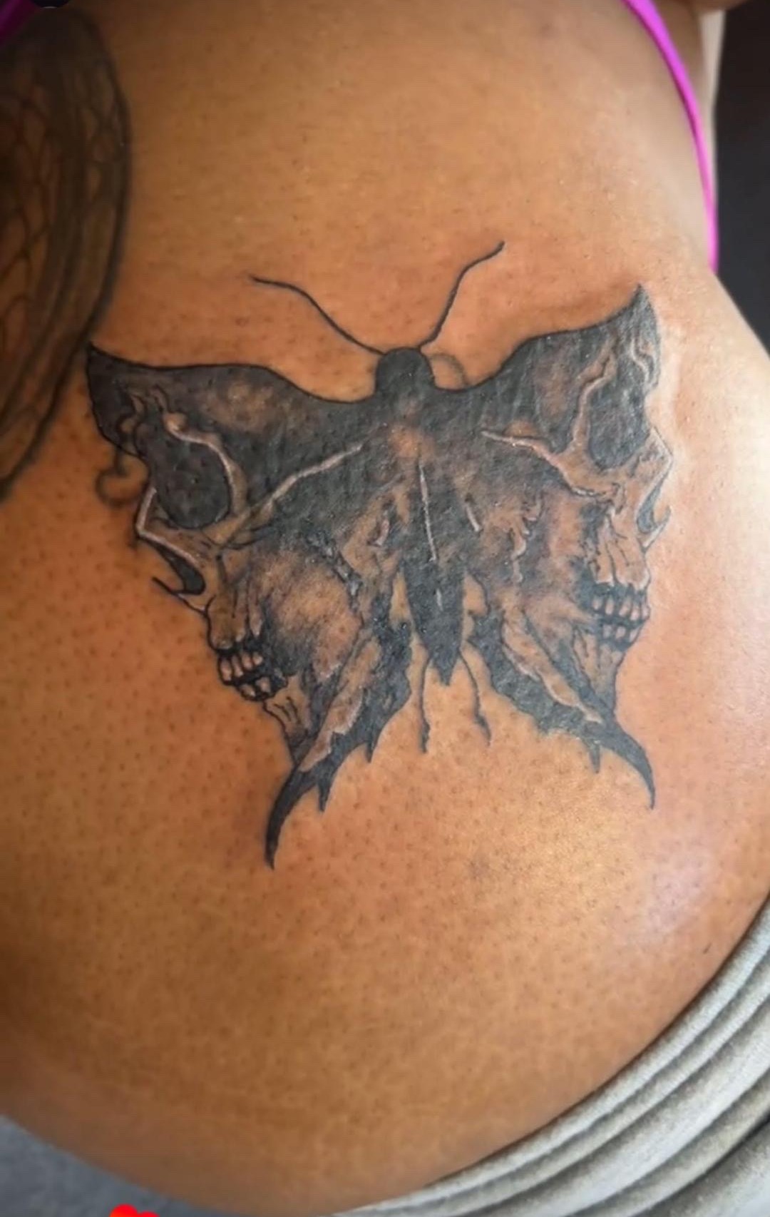 Moth and skull tattoo on ribs